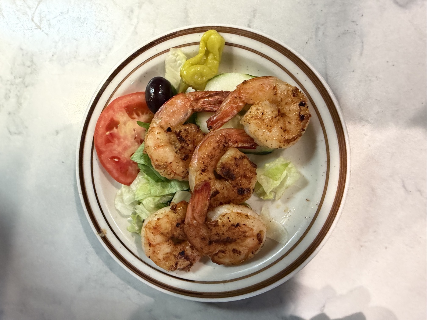 Grilled shrimp served over salad